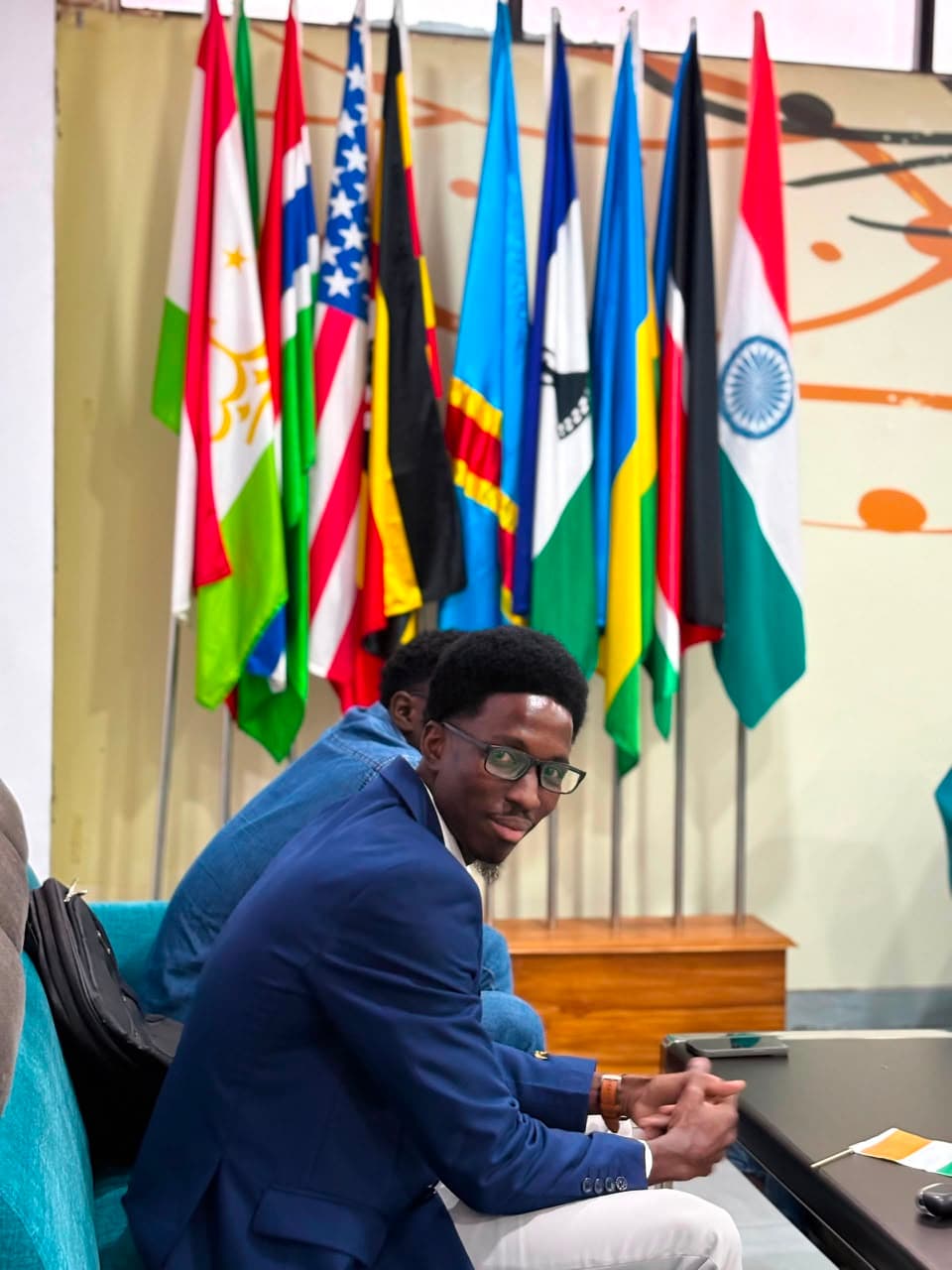 Membre de l'ADEIO devant les drapeaux des nations